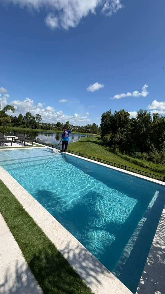 Technician skimming a lakefront pool