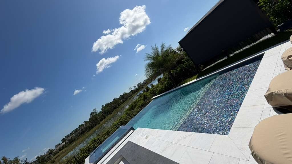 Glass tile infinity pool overlooking wetlands