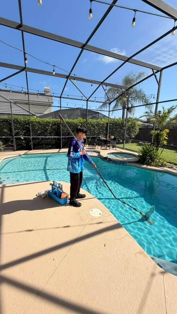 Technician vacuuming a screened pool