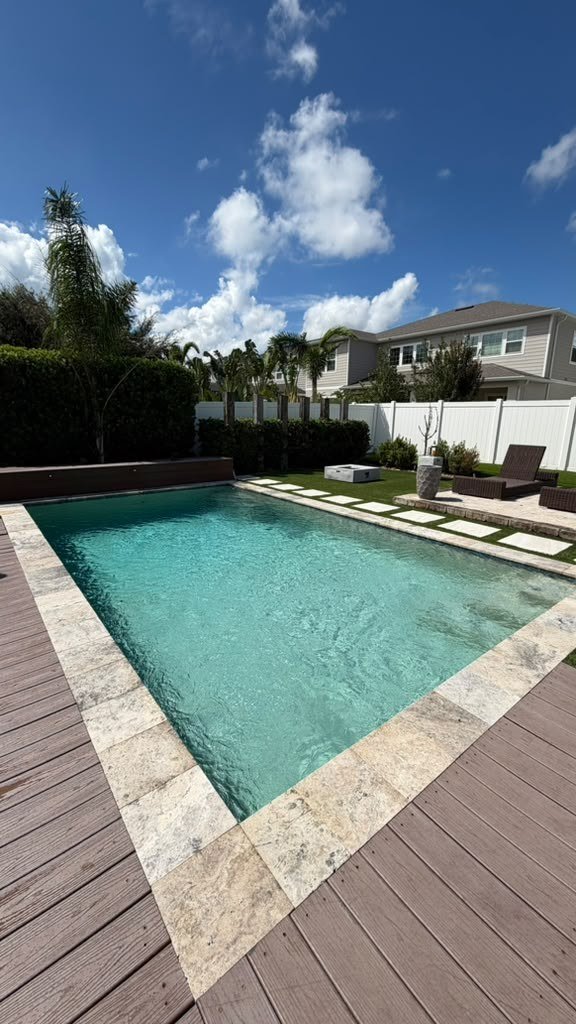 Backyard pool with paver deck and turf lawn