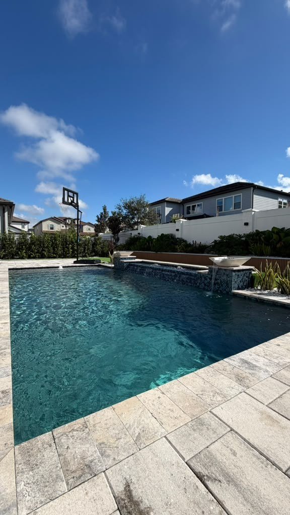 Pool with raised spillover spa and stone water bowls